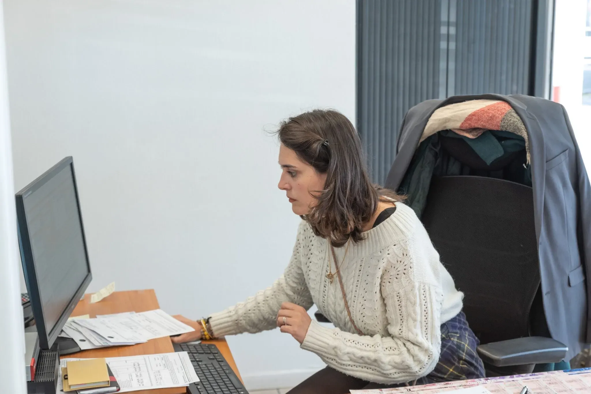 Conseillère funéraire travaillant sur un ordinateur à son bureau d'accueil.